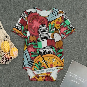 May include: A short-sleeved baby bodysuit with a colorful Italian-themed design. The pattern includes images of pizza, tomatoes, the Leaning Tower of Pisa, and the Italian flag. The words "BON APPET" are printed on the bottom.
