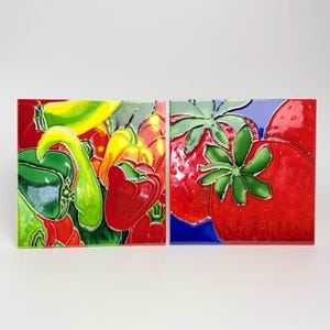 Puede incluir: Dos azulejos de cerámica con imágenes coloridas de frutas y verduras. El primer azulejo presenta un primer plano de pimientos rojos, verdes y amarillos. El segundo azulejo presenta un primer plano de fresas rojas con hojas verdes.