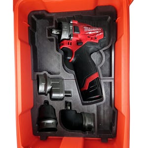 Könnte beinhalten: Ein roter und schwarzer Milwaukee FUEL Bohrer mit einem Winkelaufsatz, einem geraden Aufsatz und einem Bohrfutter in einem roten Kunststoffkoffer.