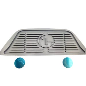 May include: Gray rubber doorstop with a raised LG logo and a textured surface. The doorstop is shaped like a wedge and has two round blue rubber feet.