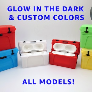 May include: A collection of Yeti coolers in various colors, including red, blue, white, green, and yellow. The coolers are all the same size and have a similar design. The text "Glow in the dark & custom colors" and "All models!" is visible in the image.