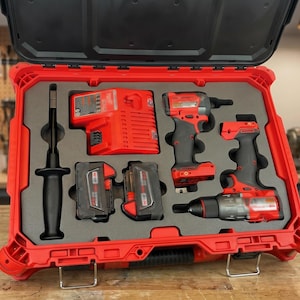 Könnte beinhalten: Roter Werkzeugkoffer mit einem Satz roter und schwarzer Elektrowerkzeuge. Das Set enthält einen Bohrer, einen Schlagschrauber, ein Ladegerät, Batterien und andere Werkzeuge. Der Koffer ist geöffnet und zeigt die Werkzeuge.