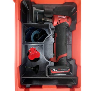 May include: A red and black power tool kit with various accessories. The kit contains a red and black power tool, blue sanding discs, and other small parts. The kit is stored in a red plastic case with black compartments.