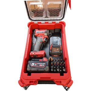 May include: A red and black tool case with a clear lid, open to reveal a cordless drill, batteries, and drill bits. The case is designed for easy transport and organization of tools.