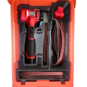 Puede incluir: Una herramienta eléctrica roja y negra con una banda de lijado en una caja de plástico roja. La herramienta está en un compartimento con una banda de lijado en un compartimento separado.