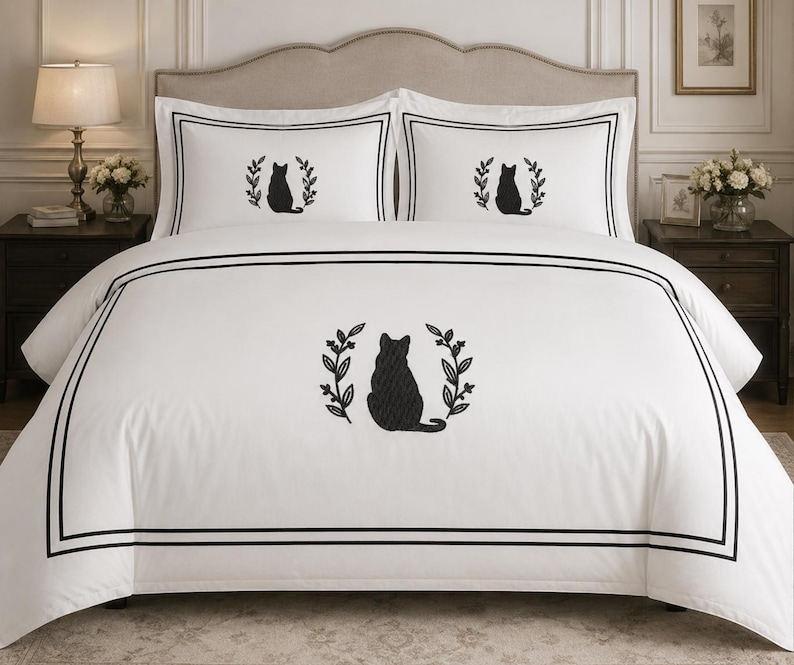 Pu&ograve; includere: Un copripiumino bianco e due federe abbinate con la sagoma ricamata in nero di un gatto seduto all'interno di una corona di foglie. Il set di biancheria da letto &egrave; decorato con un doppio bordo nero sul copripiumino e sulle federe.