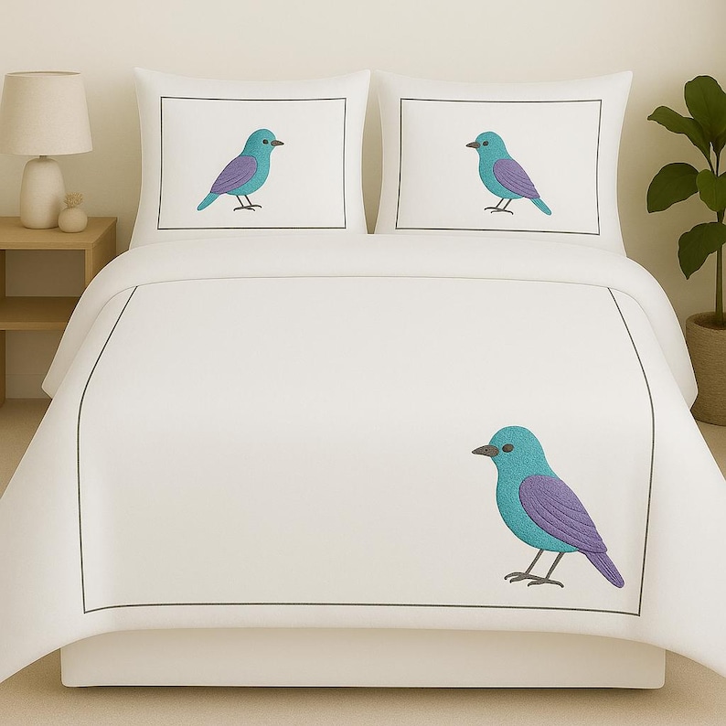 Puede incluir: Un juego de cama blanco que consta de un edred&oacute;n y dos fundas de almohada, cada una con un borde rectangular gris fino. El dise&ntilde;o incluye p&aacute;jaros bordados en turquesa y morado centrados en las almohadas y uno en la esquina inferior derecha.