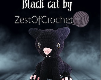 May include: Black crocheted cat with pink paws and a pink nose. The cat is sitting on a wooden surface. The text "Black cat by ZestOfCrochet" is above the cat.