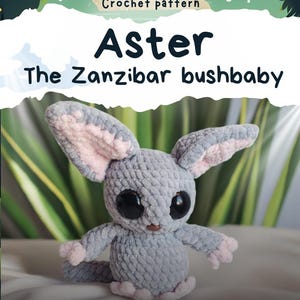May include: A crocheted gray Aster the Zanzibar bushbaby plushie with large black eyes and pink accents on the ears and paws. The image includes the text "Crochet pattern" and "Aster The Zanzibar bushbaby". The Etsy shop handle @ZestOfCrochet is also visible.