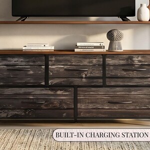 May include: A rectangular media console featuring a black metal frame and five drawers with a dark, weathered wood grain finish. The unit includes a top shelf for storage and a built-in charging station. The design incorporates horizontal drawer pulls.