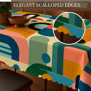 May include: A colorful tablecloth with a geometric design featuring pink, blue, green, and yellow shapes. The tablecloth has scalloped edges and the text "ELEGANT SCALLOPED EDGES" at the top. The table is set with a wooden bowl and a potted plant.