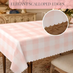 May include: A pink and white checkered tablecloth with elegant scalloped edges. The tablecloth is draped over a wooden table, creating a soft and inviting aesthetic. The text "ELEGANT SCALLOPED EDGES" is displayed at the top of the image.