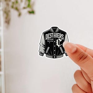 May include: Black and white sticker of a varsity jacket with the text "DESTRIERS CAPTAIN RAYVN TEW" and a letter "C" on the front.