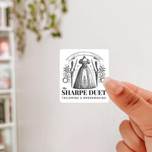 Puede incluir: Logotipo en blanco y negro para un negocio de sastrería y confección llamado "The Sharpe Duet". El logotipo presenta una ilustración estilizada de un vestido, tijeras e hilo.