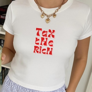 Tax The Rich Slogan Baby Tee Bold Graphic Crop Top Political Slogan T-Shirt Minimalist Streetwear White Fitted Tee for Women