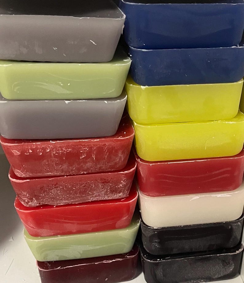 May include: A stack of rectangular wax blocks in various colors, including gray, green, yellow, red, white, and black.