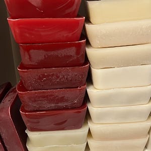 May include: A stack of red and white rectangular bars of soap. The red bars are stacked on the left and the white bars are stacked on the right.