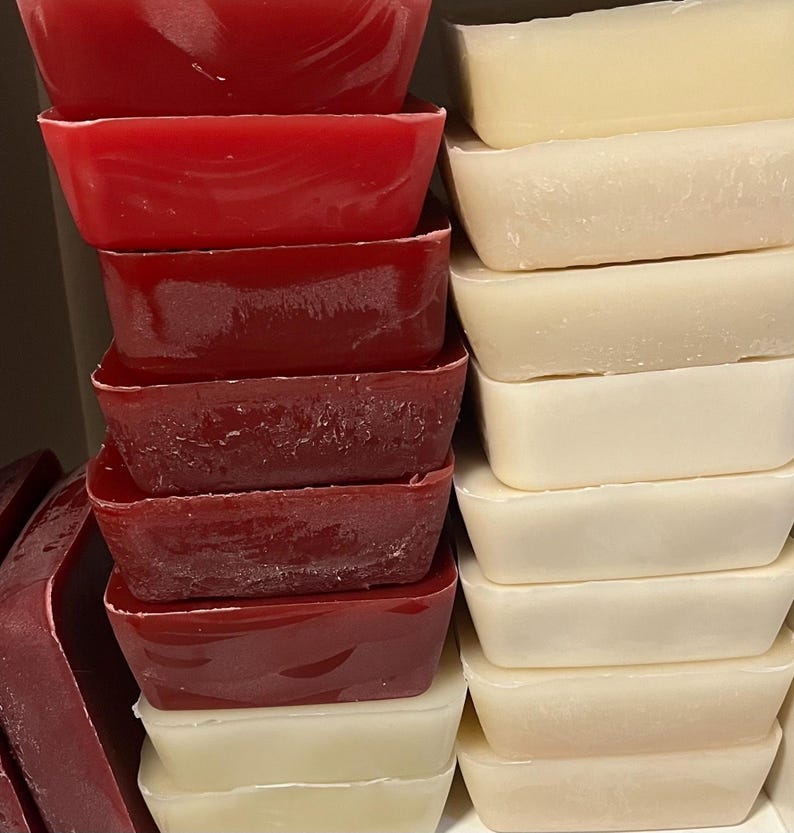 May include: A stack of red and white rectangular bars of soap. The red bars are stacked on the left and the white bars are stacked on the right.