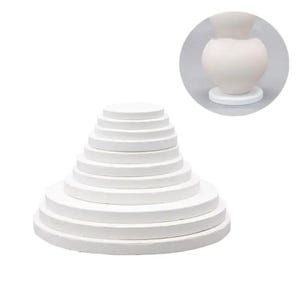 May include: A set of white, round, tiered display stands. The stands are arranged in a pyramid shape, with each tier decreasing in size. A smaller, similar stand is shown in a circular inset. These stands are ideal for displaying pottery or other decorative items.