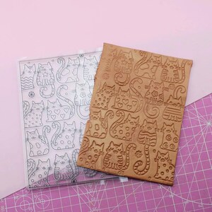 Peut inclure: Un tampon en acrylique transparent et un tampon en argile marron, tous deux avec des motifs de chats. Le tampon acrylique présente des contours de chats avec divers motifs. Le tampon en argile a des motifs de chats en relief.