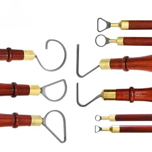 May include: A collection of ten pottery sculpting tools featuring dark brown wooden handles with brass ferrules and various metal wire loop heads, including circular, triangular, and angled shapes for clay carving and shaping tasks.