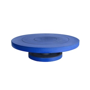 Op de afbeelding: Een blauwe pottenbakkersschijf met een glad, rond oppervlak. De draaischijf is gemaakt van plastic en heeft een zwarte basis.