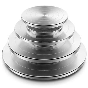 Könnte beinhalten: Ein Stapel von vier silberfarbenen Torten-Drehtellern. Jeder Drehteller hat eine andere Größe, mit konzentrischen Kreisen, die in die Oberfläche geätzt sind. Die Drehteller sind aus Metall und für die Tortendekoration bestimmt.