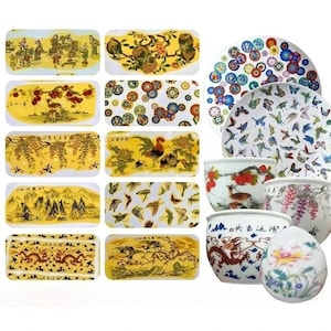 Può includere: Una collezione di oggetti decorativi in ceramica con disegni di ispirazione asiatica tradizionale. Include vassoi rettangolari, piatti, ciotole e un ornamento a forma di uovo. Gli articoli presentano illustrazioni dettagliate di paesaggi, animali e motivi floreali.