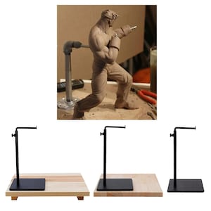 May include: Three black metal display stands with a rectangular base and a curved arm. The stands are on a light wood surface.