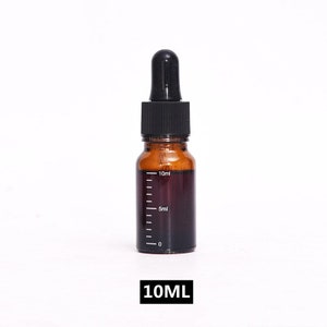 May include: A 10 ml amber glass bottle with a black dropper top. The bottle has a graduated scale on the side, with markings for 5 ml and 10 ml.