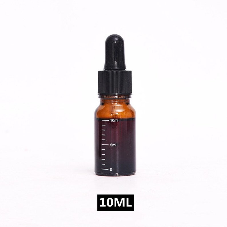 May include: A 10 ml amber glass bottle with a black dropper top. The bottle has a graduated scale on the side, with markings for 5 ml and 10 ml.