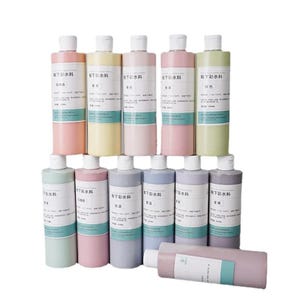 Puede incluir: Una colección de botellas de colores pastel con tapas y etiquetas blancas. Las botellas están dispuestas en filas, con tonos de rosa, amarillo, verde y azul. Las etiquetas presentan caracteres chinos. Un recipiente cilíndrico descansa en la parte inferior.