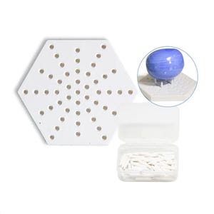 Pode incluir: Um tabuleiro hexagonal branco com uma grade de pequenos orifícios circulares, acompanhado por um recipiente de armazenamento de plástico transparente cheio de numerosos pinos brancos pontiagudos e um detalhe circular mostrando uma pedra azul.