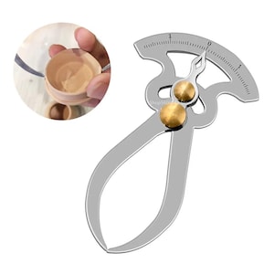 以下が含まれることがあります： 真鍮色の調整ノブと湾曲した測定スケールを備えた、銀色の金属製キャリパーツール。 このツールは、木製容器の内径を測定するように設計されています。 埋め込み画像は、使用中のツールを示しています。