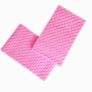 Pode incluir: Dois moldes retangulares de silicone rosa com um padrão repetitivo em relevo de escamas de peixe ou de sereia em toda a superfície. Os tapetes flexíveis têm uma textura consistente de pequenas formas semicirculares sobrepostas.