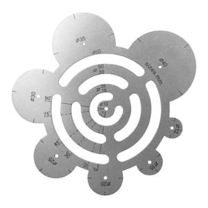 Puede incluir: Una plantilla de círculo de metal plateado con múltiples círculos de diferentes tamaños, que van desde 10 mm hasta 40 mm. La plantilla está marcada con medidas en grados y el texto "sizes, mm".