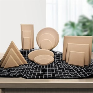 Peut inclure: Ensemble de présentoirs et plateformes en carton brun clair de différentes tailles. Les formes comprennent des formes rectangulaires, carrées, ovales, circulaires et triangulaires. Ils sont disposés sur un tissu à carreaux noir et blanc.