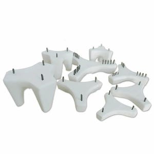 Puede incluir: Un conjunto de soportes de cerámica blanca para horno, cada uno con forma de estrella de tres puntas y pequeñas púas metálicas verticales que sobresalen de las superficies superiores para sostener la cerámica durante la cocción.