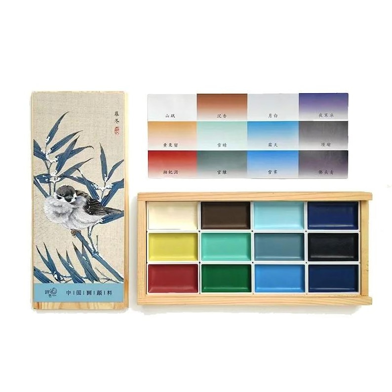 May include: A watercolor paint set with a wooden box containing 16 color palettes. The set includes a decorative box with a bird and bamboo illustration. A separate card displays color swatches with Chinese characters.