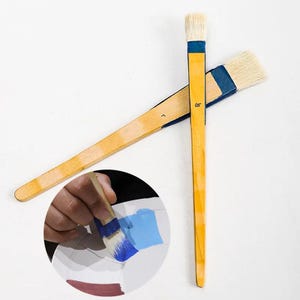 Puede incluir: Dos pinceles de mango de madera con cerdas azules y blancas. Los pinceles están cruzados uno sobre el otro. Un pincel tiene el número "0,5" impreso en el mango.