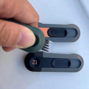 May include: Two grey and black USB drives with a copper coloured accent. The top drive has a small brush attached to it. The bottom drive has the number "12" printed on it.
