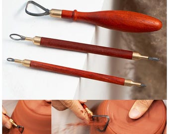 May include: Set of three pottery tools with wooden handles. The tools have different shaped metal tips for sculpting and shaping clay. The tools are shown being used to shape a clay pot.
