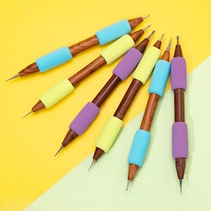 May include: Six tools with wooden handles, metal tips, and colourful grips. The dark brown handles have a wood grain pattern. The grips are blue, yellow, and purple. The tools are arranged diagonally against a yellow and green background.