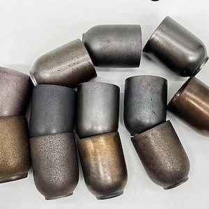 May include: A collection of ten ceramic mugs in various shades of brown and grey. The mugs have a textured, rustic look and are perfect for enjoying a hot beverage.