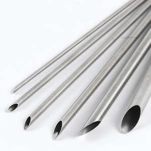 Peut inclure: Ensemble de six douilles à pâtisserie en acier inoxydable avec des ouvertures rondes de différentes tailles. Les douilles sont utilisées pour décorer les gâteaux et les pâtisseries.