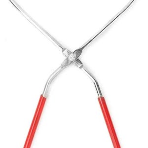 May include: A pair of silver-colored tongs with red handles. The tongs have curved ends with a pointed tip on one side and a U-shaped end on the other. The handles are a bright red color.