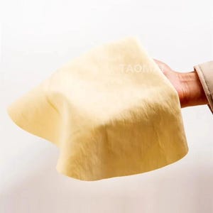 May include: A set of three ceramic mugs with a speckled, matte finish. The mugs are in shades of cream, light gray, and dark gray. Each mug has a simple, minimalist design and a rounded handle.