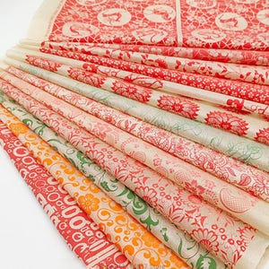May include: A stack of patterned paper sheets in various colors. The designs include floral patterns, circles, and other decorative elements in red, orange, and green. The paper has a slightly translucent quality.