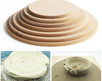 May include: A set of seven round, brown pottery wheels of varying sizes, stacked in a pyramid shape. The wheels are made of a rough, textured material. The image also shows two examples of the wheels being used with clay.