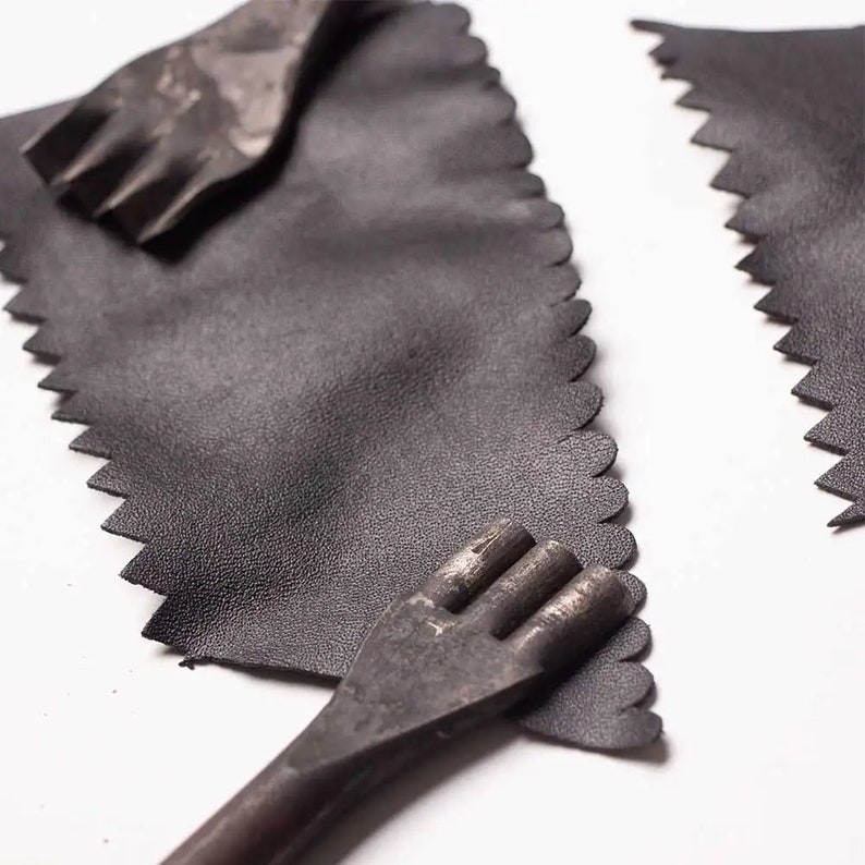 May include: Two black leather pieces with scalloped edges and two metal tools for punching holes in leather.